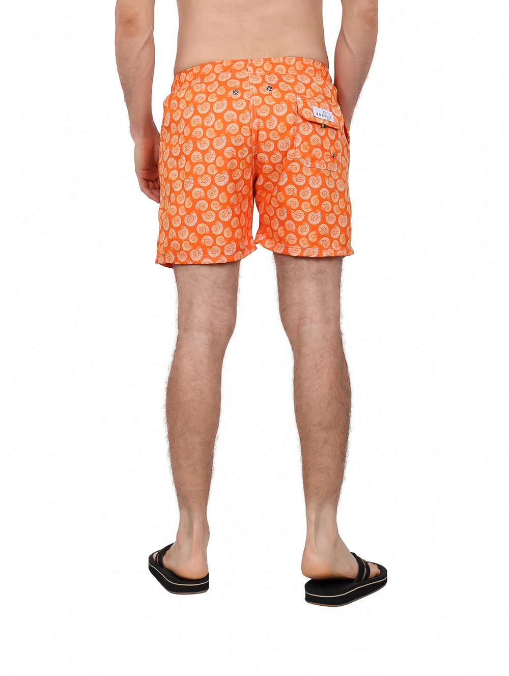 Hombre vistiendo un traje de baño corto color naranja con estampado blanco y cordón en la cintura.
