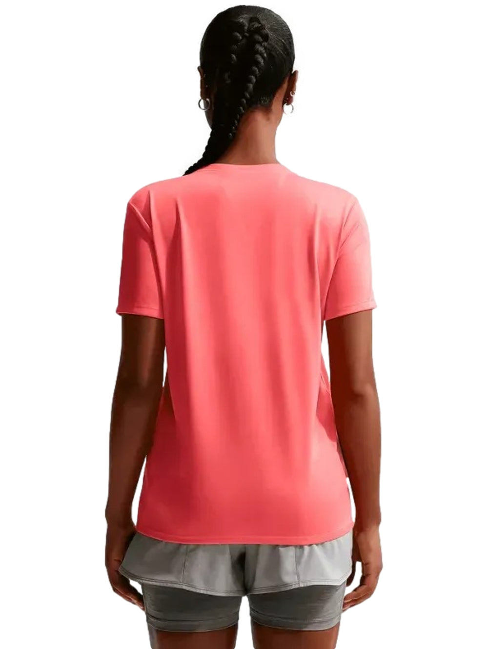 Mujer vistiendo playera deportiva Nike color coral y pantalones cortos grises.