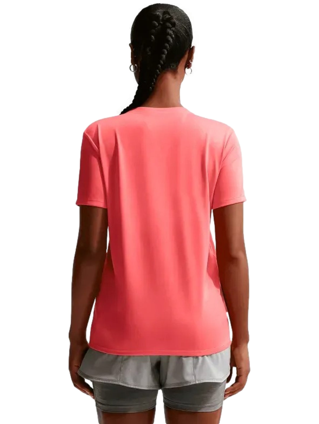 Mujer vistiendo playera deportiva Nike color coral y pantalones cortos grises.