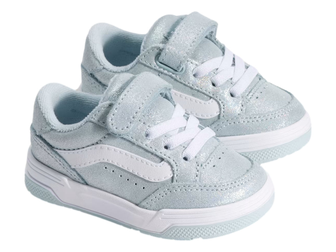 Tenis VANS infantiles color azul claro holográfico con correa de velcro y suela blanca.