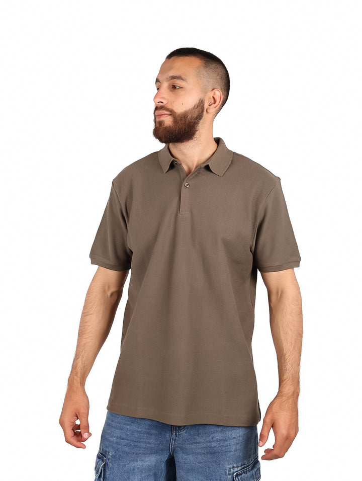 Hombre vistiendo una playera polo color olivo de manga corta.