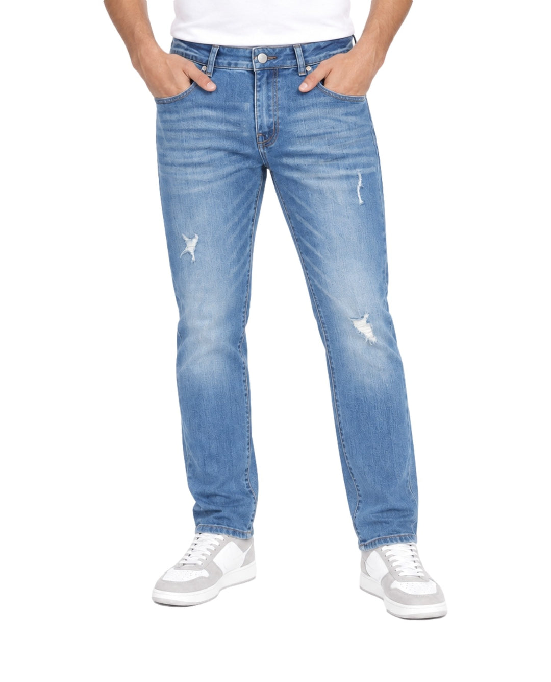 Hombre vistiendo jeans azul medio stone con detalles desgastados y rotos en las piernas.