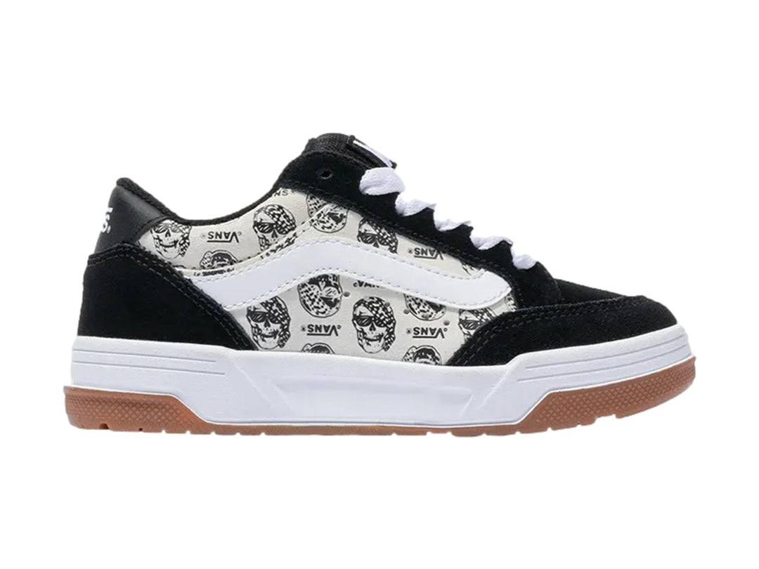 Tenis Vans blancos y negros con estampado de calaveras y suela de goma color marrón.