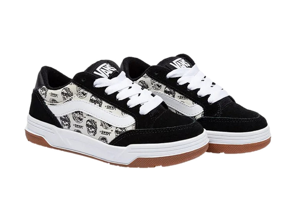 Tenis Vans blancos y negros con estampado de calaveras y suela de goma color marrón.