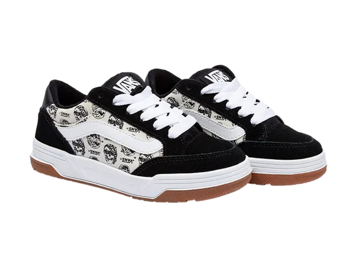 Tenis Vans blancos y negros con estampado de calaveras y suela de goma color marrón.