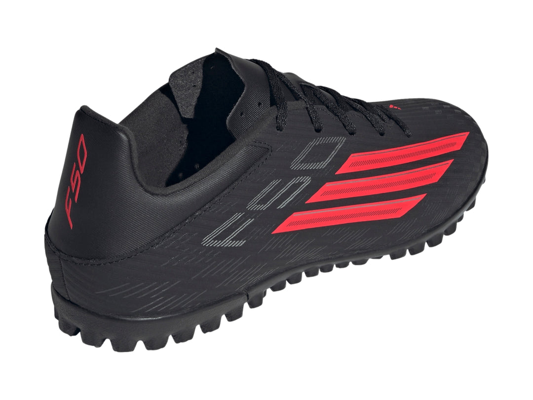 Calzado de fútbol Adidas F50 Club TF color negro con tres franjas rojas en el costado.