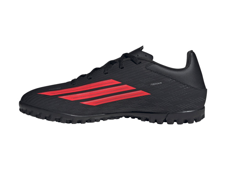 Calzado de fútbol Adidas F50 Club TF color negro con tres franjas rojas en el costado.