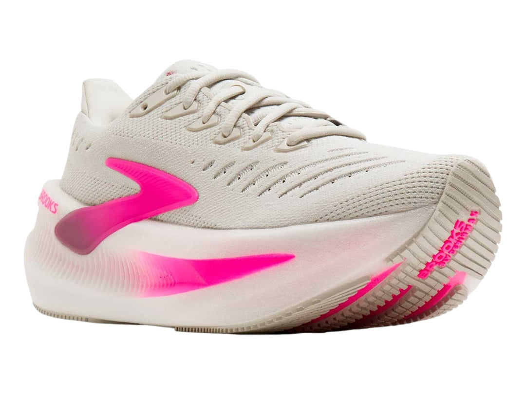 Tenis deportivos Brooks color beige con detalles en rosa brillante y suela blanca gruesa.