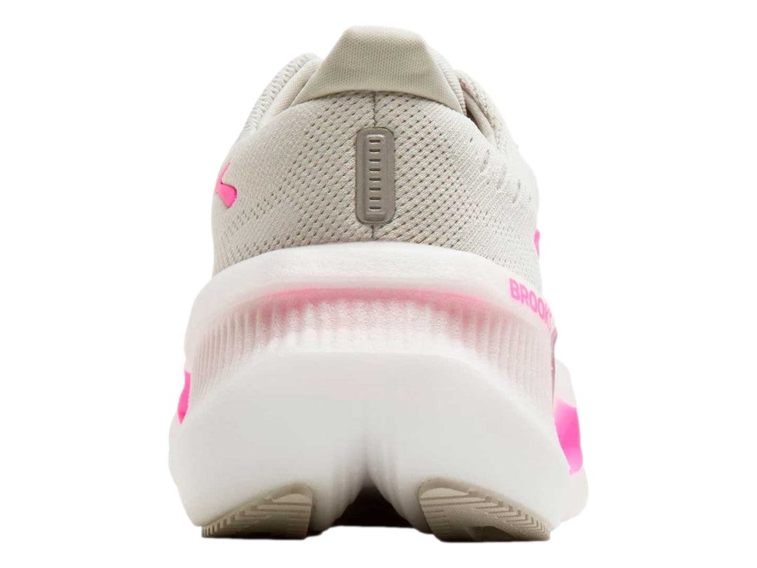 Tenis deportivos Brooks color beige con detalles en rosa brillante y suela blanca gruesa.