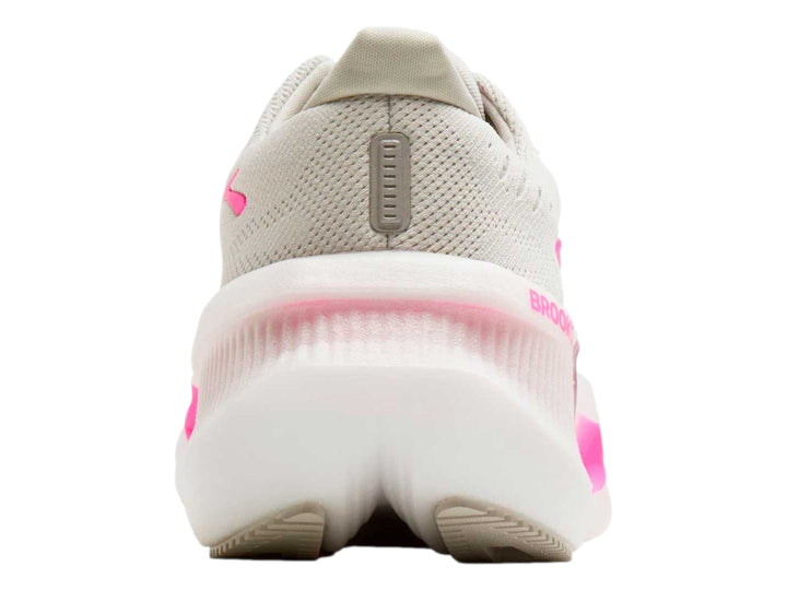 Tenis deportivos Brooks color beige con detalles en rosa brillante y suela blanca gruesa.