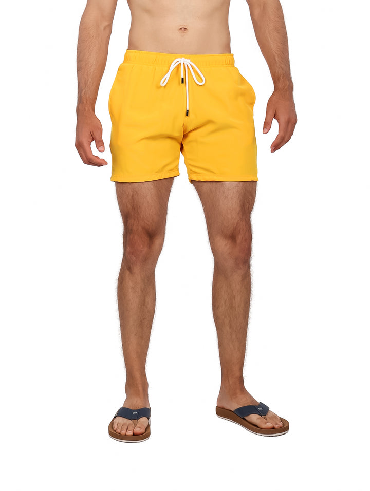 Hombre vistiendo un traje de baño corto de color amarillo con cordón blanco.