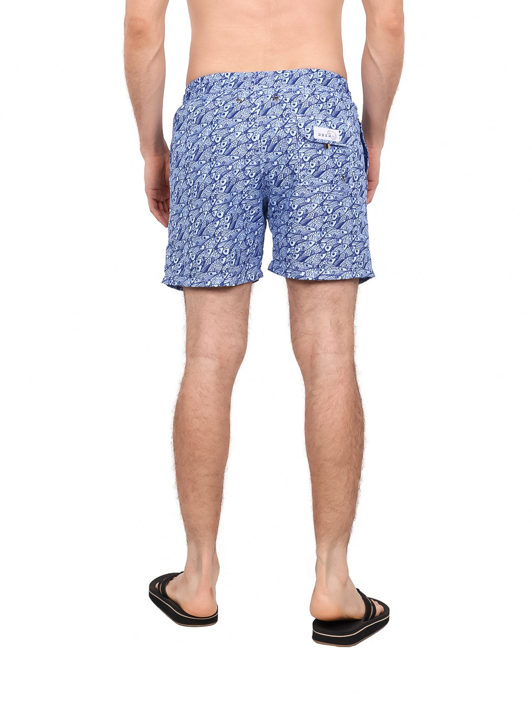 Hombre vistiendo un traje de baño corto color azul con estampado blanco y cordón ajustable.