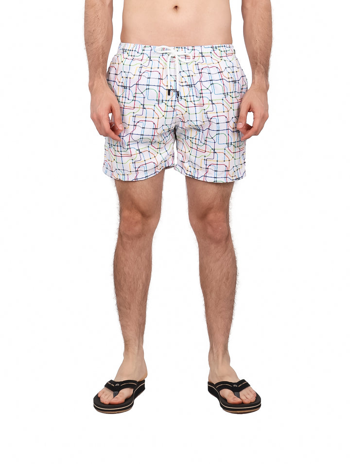 Hombre vistiendo un traje de baño corto color blanco con estampado de líneas multicolores.