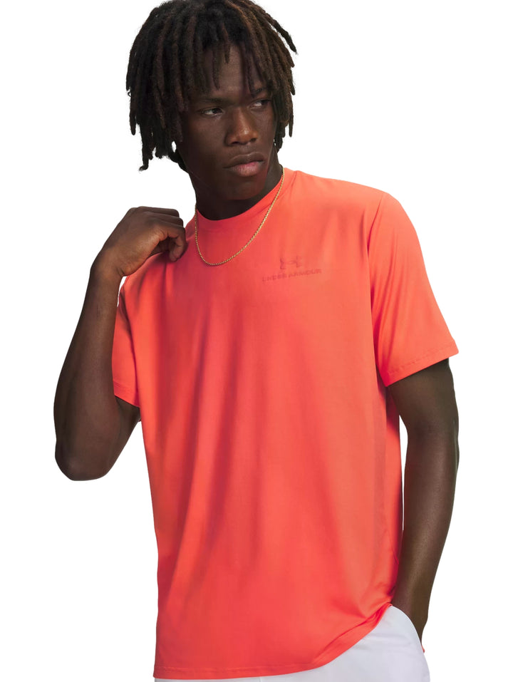 Hombre vistiendo una camiseta deportiva de color rojo vibrante de la marca Under Armour.