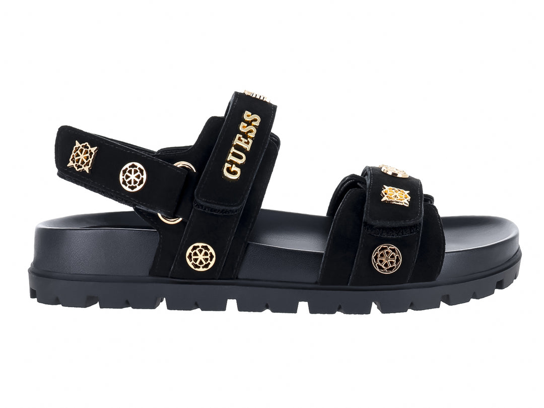 Sandalia negra de plataforma con correas y detalles metálicos dorados de la marca GUESS.