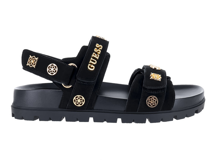 Sandalia negra de plataforma con correas y detalles metálicos dorados de la marca GUESS.