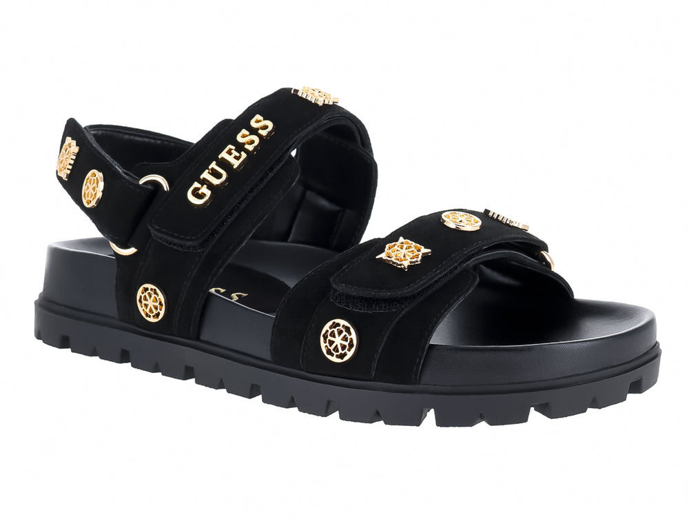 Sandalia negra de plataforma con correas y detalles metálicos dorados de la marca GUESS.