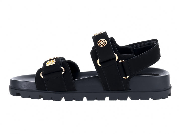 Sandalia negra de plataforma con correas y detalles metálicos dorados de la marca GUESS.