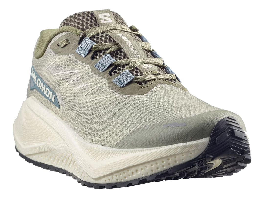 Tenis de running Salomon color verde oliva con suela blanca y detalles en azul.