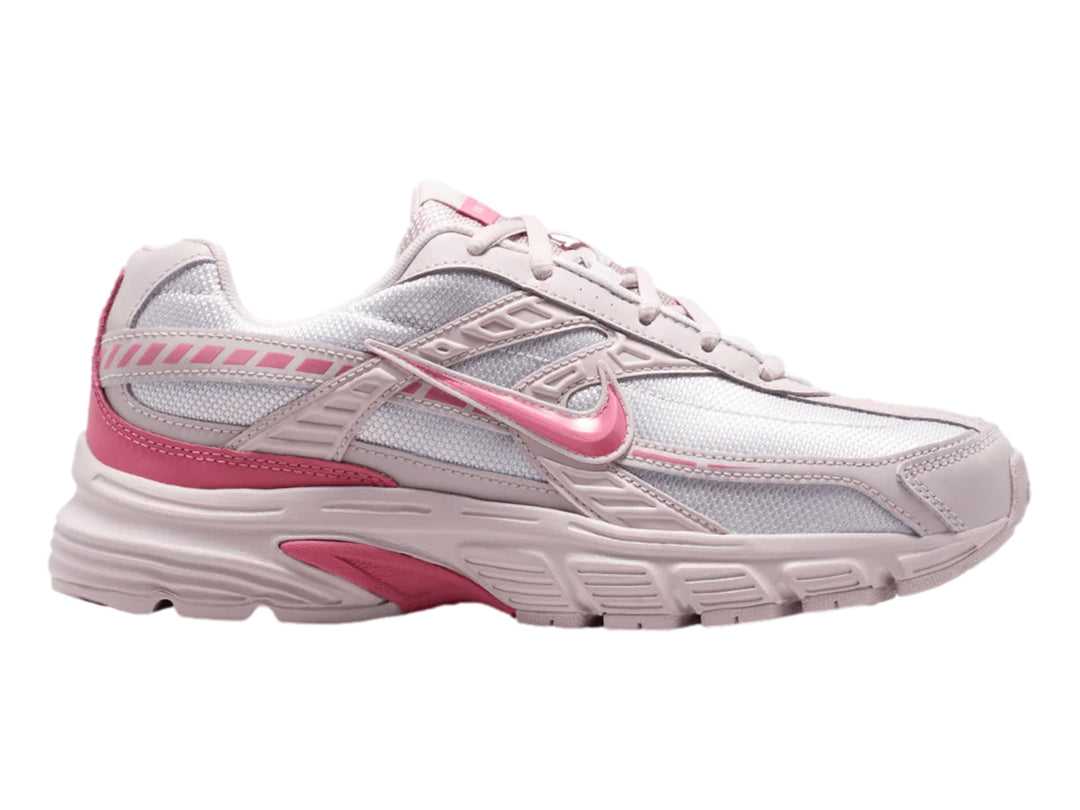 Tenis Nike Initiator en colores blanco, plata y rosa con diseño deportivo y suela robusta.