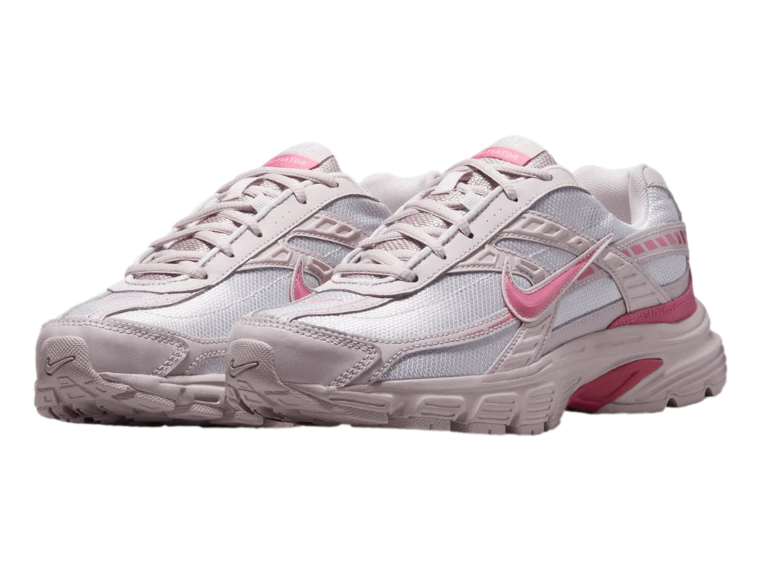 Tenis Nike Initiator en colores blanco, plata y rosa con diseño deportivo y suela robusta.