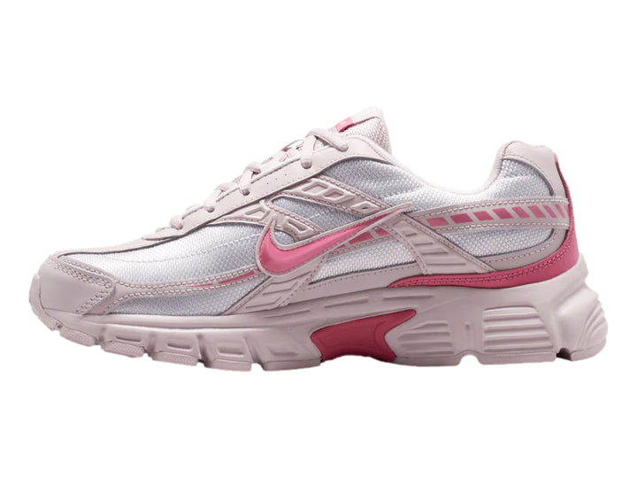 Tenis Nike Initiator en colores blanco, plata y rosa con diseño deportivo y suela robusta.