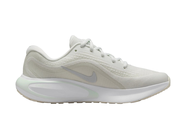 Tenis deportivos Nike Journey Run color blanco con detalles en verde claro y logotipo plateado.
