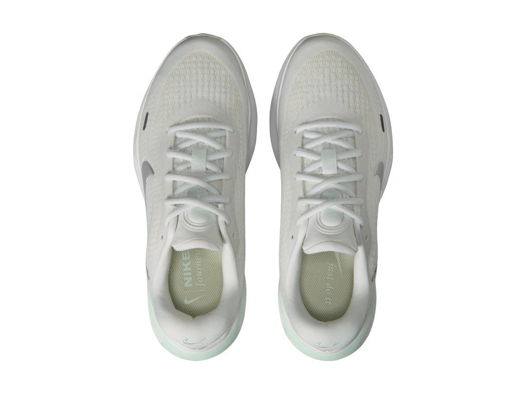 Tenis deportivos Nike Journey Run color blanco con detalles en verde claro y logotipo plateado.