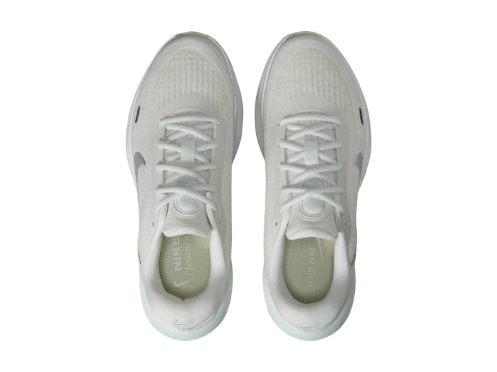 Tenis deportivos Nike Journey Run color blanco con detalles en verde claro y logotipo plateado.