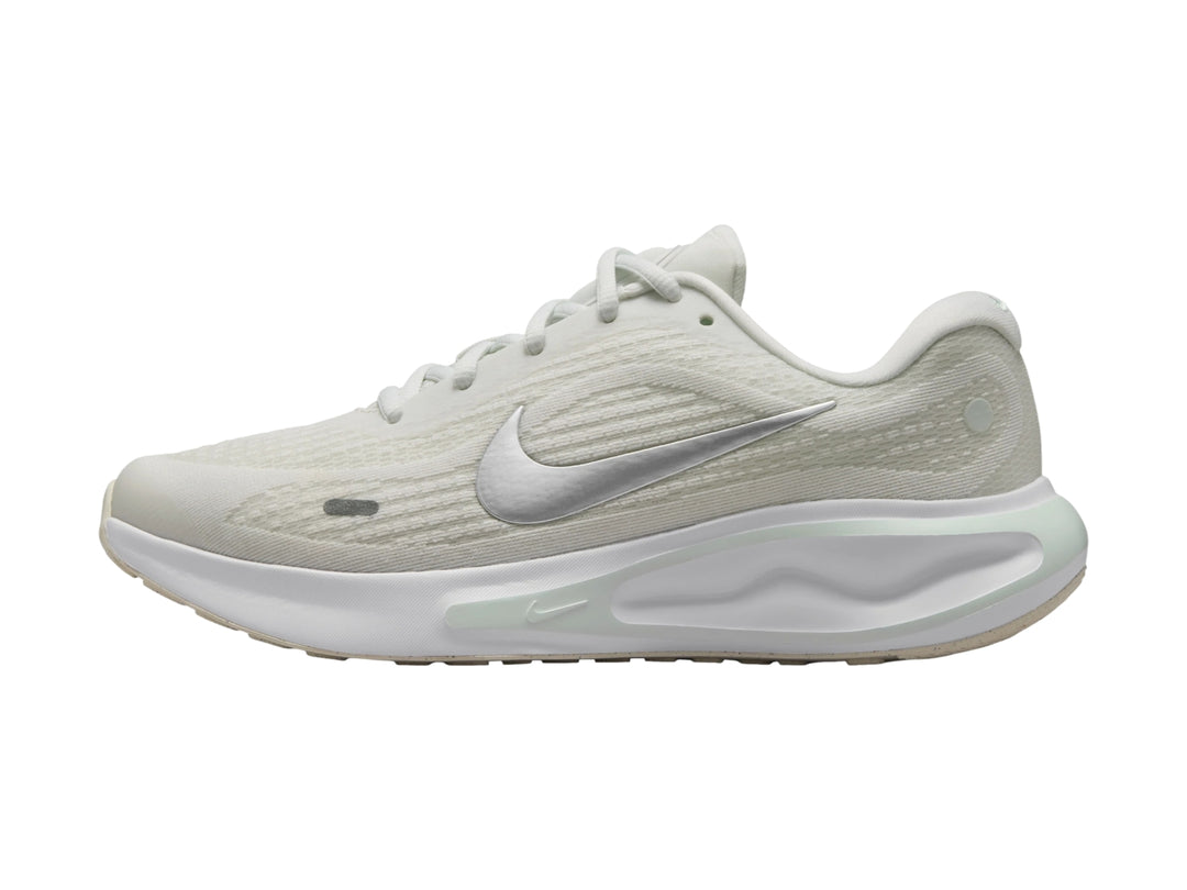 Tenis deportivos Nike Journey Run color blanco con detalles en verde claro y logotipo plateado.