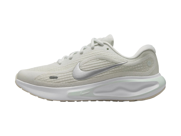 Tenis deportivos Nike Journey Run color blanco con detalles en verde claro y logotipo plateado.