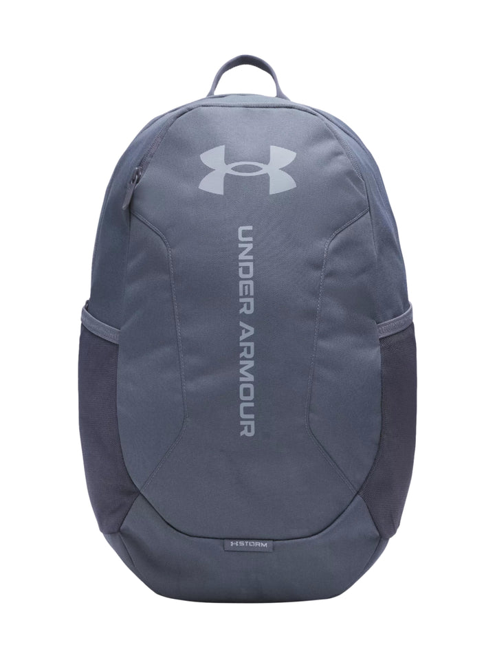 Mochila Under Armour de color gris con logotipo frontal y bolsillos laterales.