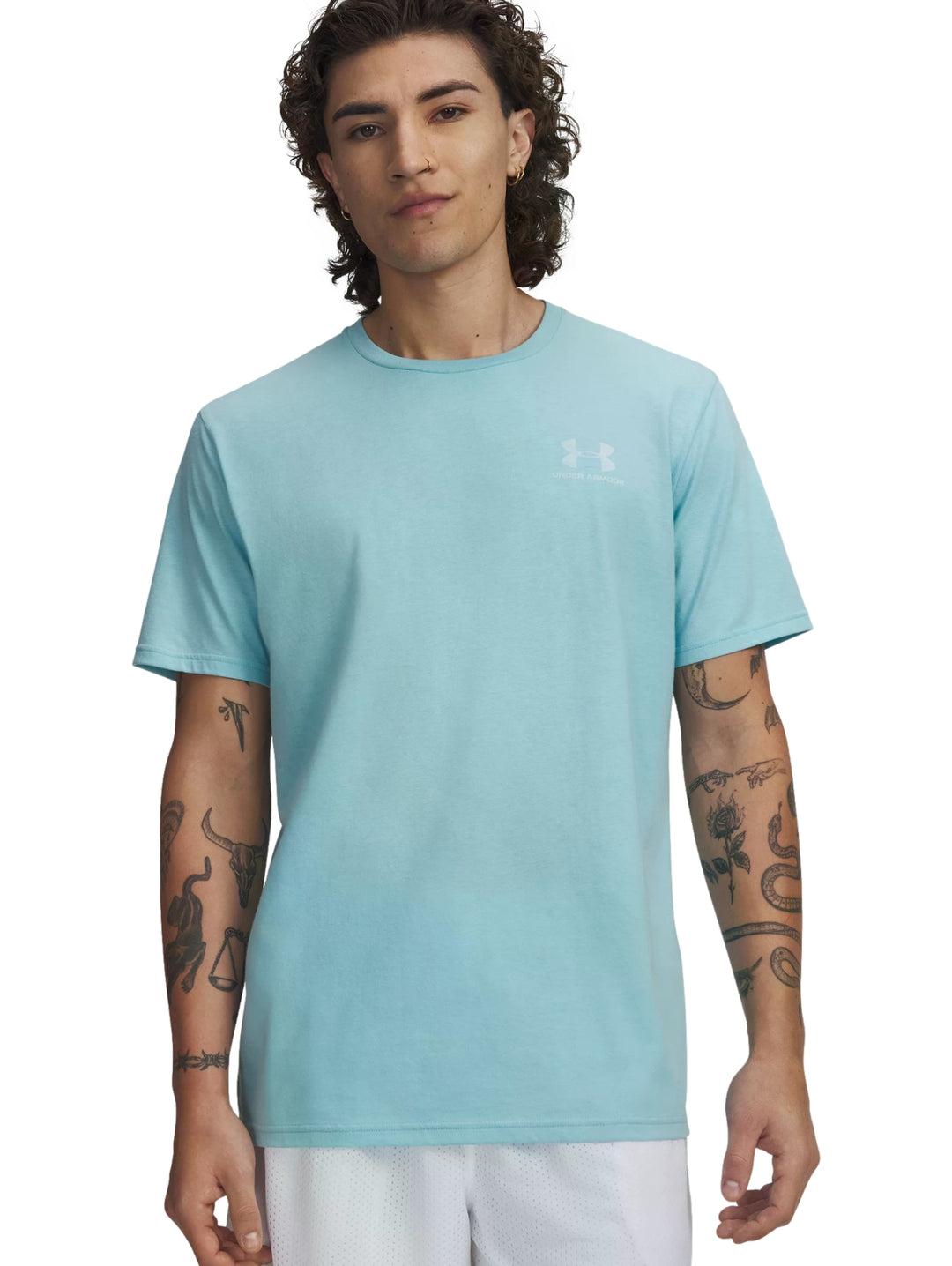 Hombre vistiendo una playera Under Armour de color azul claro con cuello redondo y manga corta.