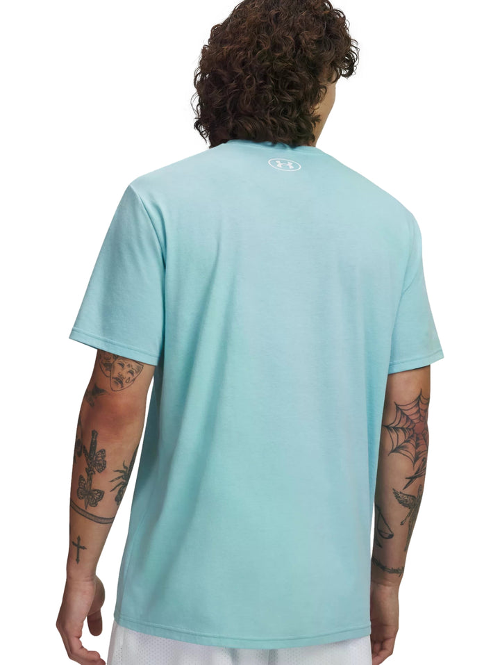 Hombre vistiendo una playera Under Armour de color azul claro con cuello redondo y manga corta.