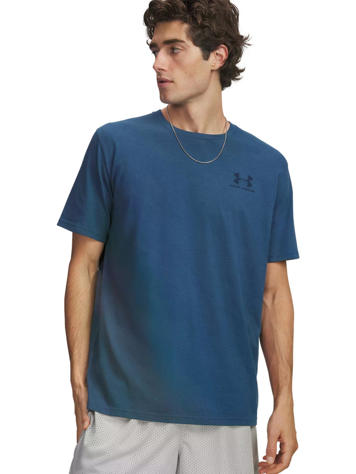 Hombre vistiendo una camiseta deportiva de color azul con logo de Under Armour en el pecho.