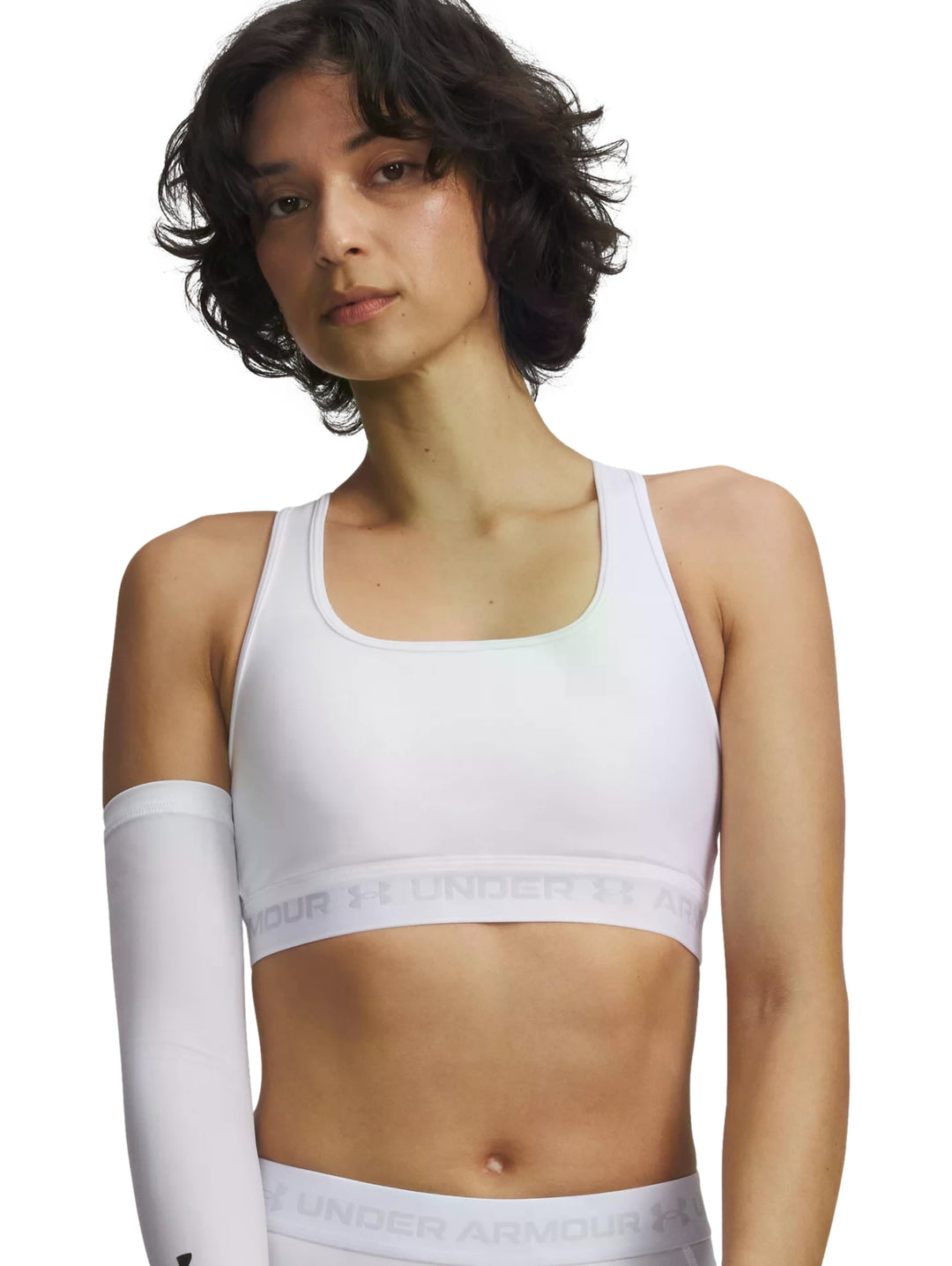 Mujer vistiendo un bra deportivo blanco de Under Armour con banda elástica en la base.