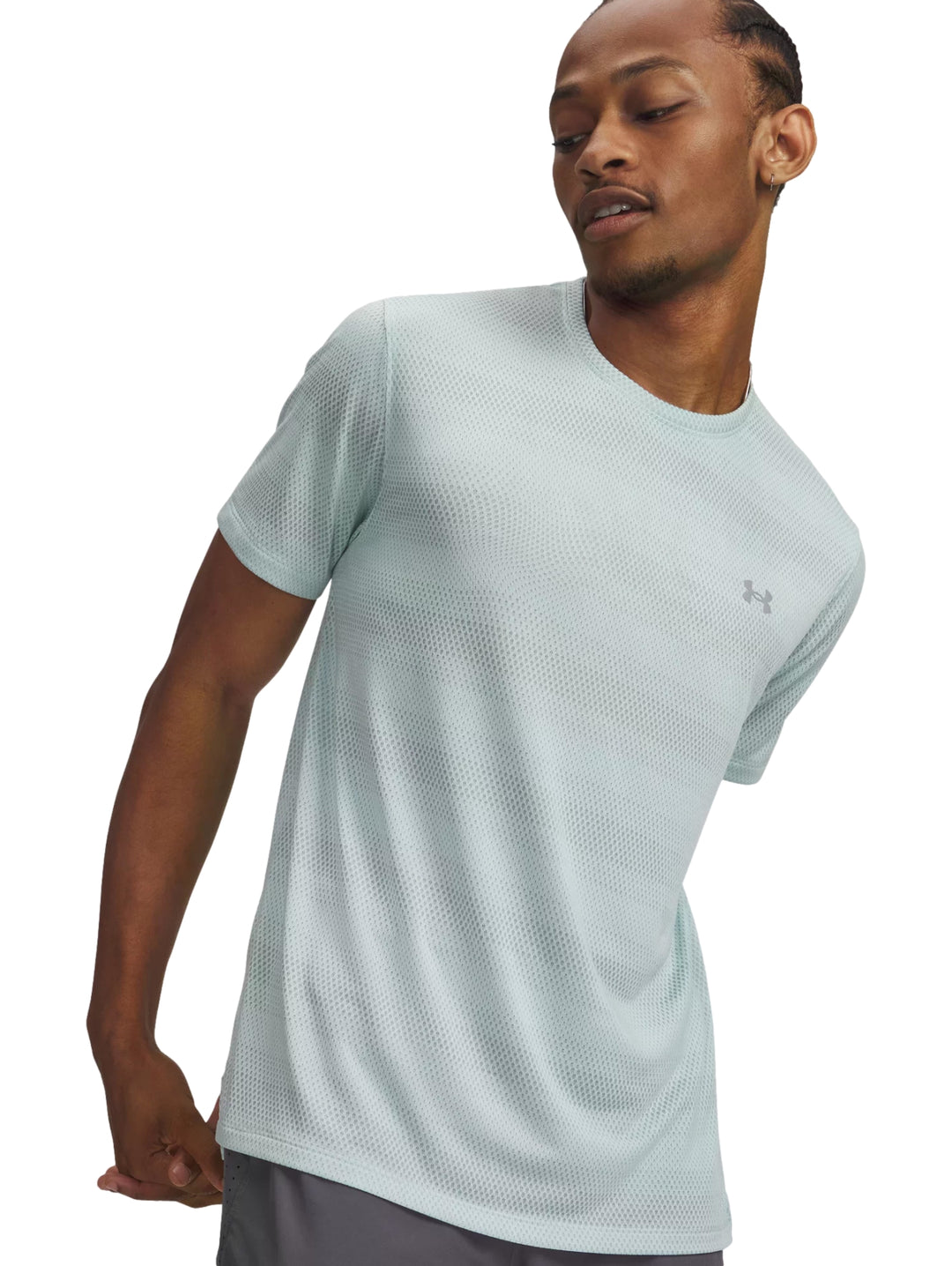 Hombre vistiendo una camiseta deportiva de manga corta color verde menta de la marca Under Armour.