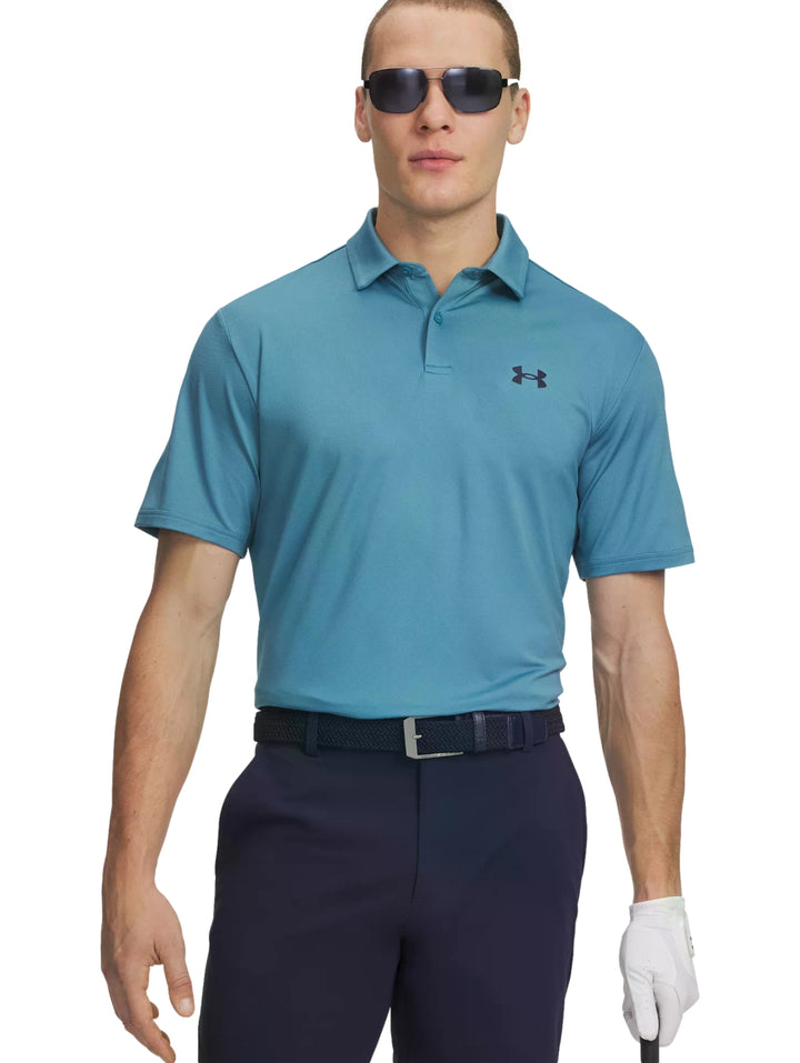 Hombre vistiendo polo deportivo Under Armour de color azul claro con cuello y manga corta.