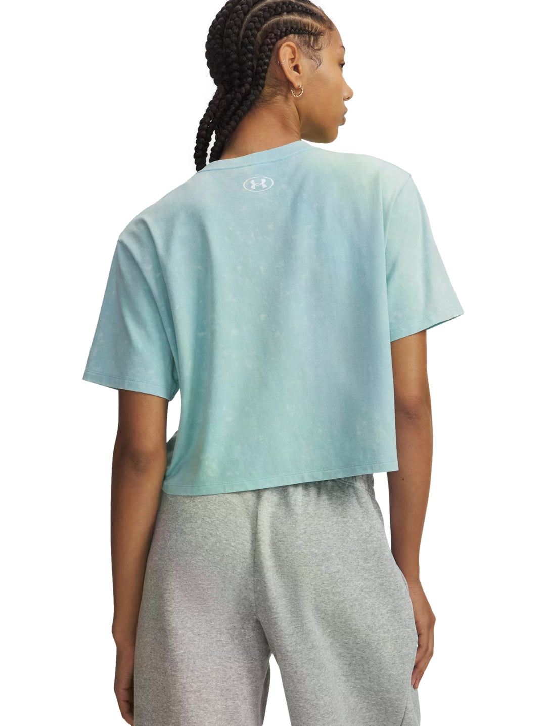 Mujer vistiendo camiseta deportiva azul claro de corte boxy y corto de Under Armour.
