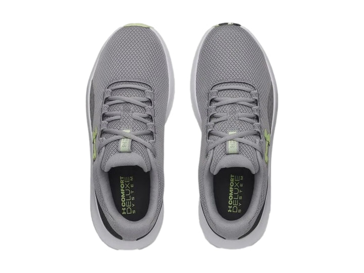 Tenis deportivos Under Armour Charged Surge 4 en color gris con suela blanca y logo en tono verde lima.