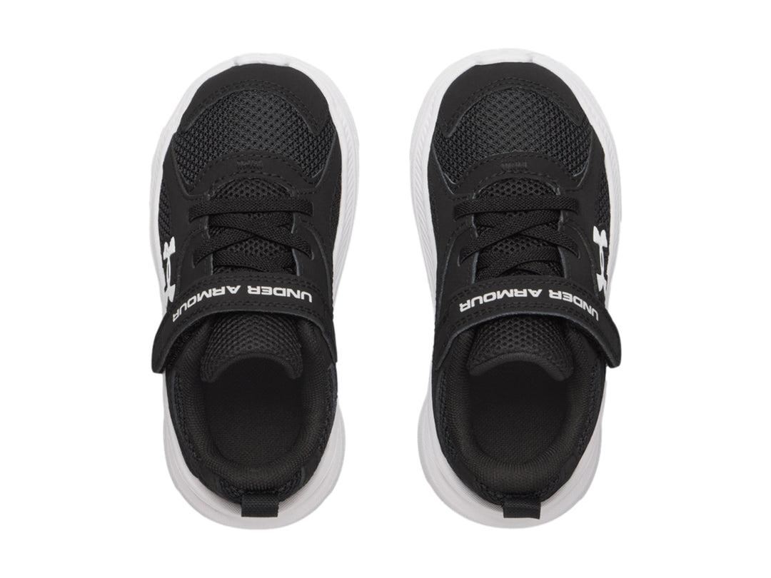Tenis deportivos Under Armour color negro con suela blanca y correa de velcro.
