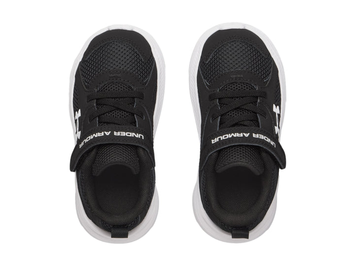 Tenis deportivos Under Armour color negro con suela blanca y correa de velcro.