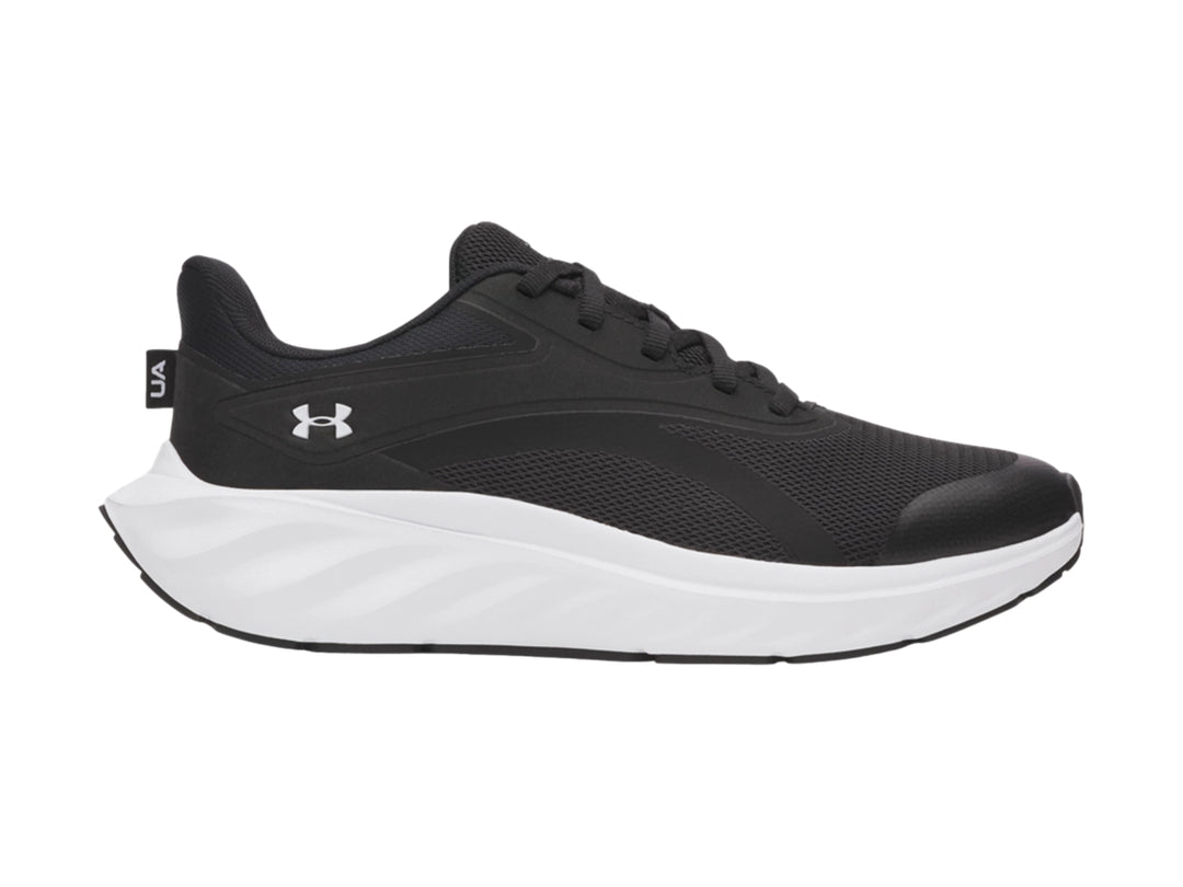 Tenis deportivos Under Armour para niño en color negro con suela blanca y logotipo blanco lateral.
