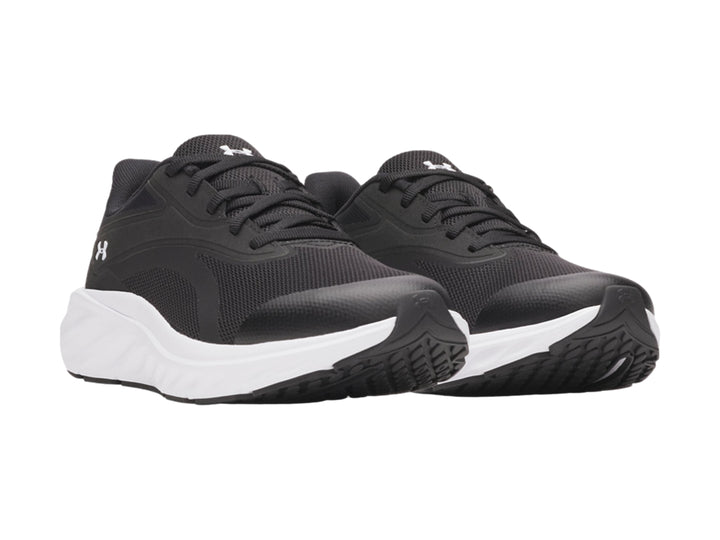 Tenis deportivos Under Armour para niño en color negro con suela blanca y logotipo blanco lateral.