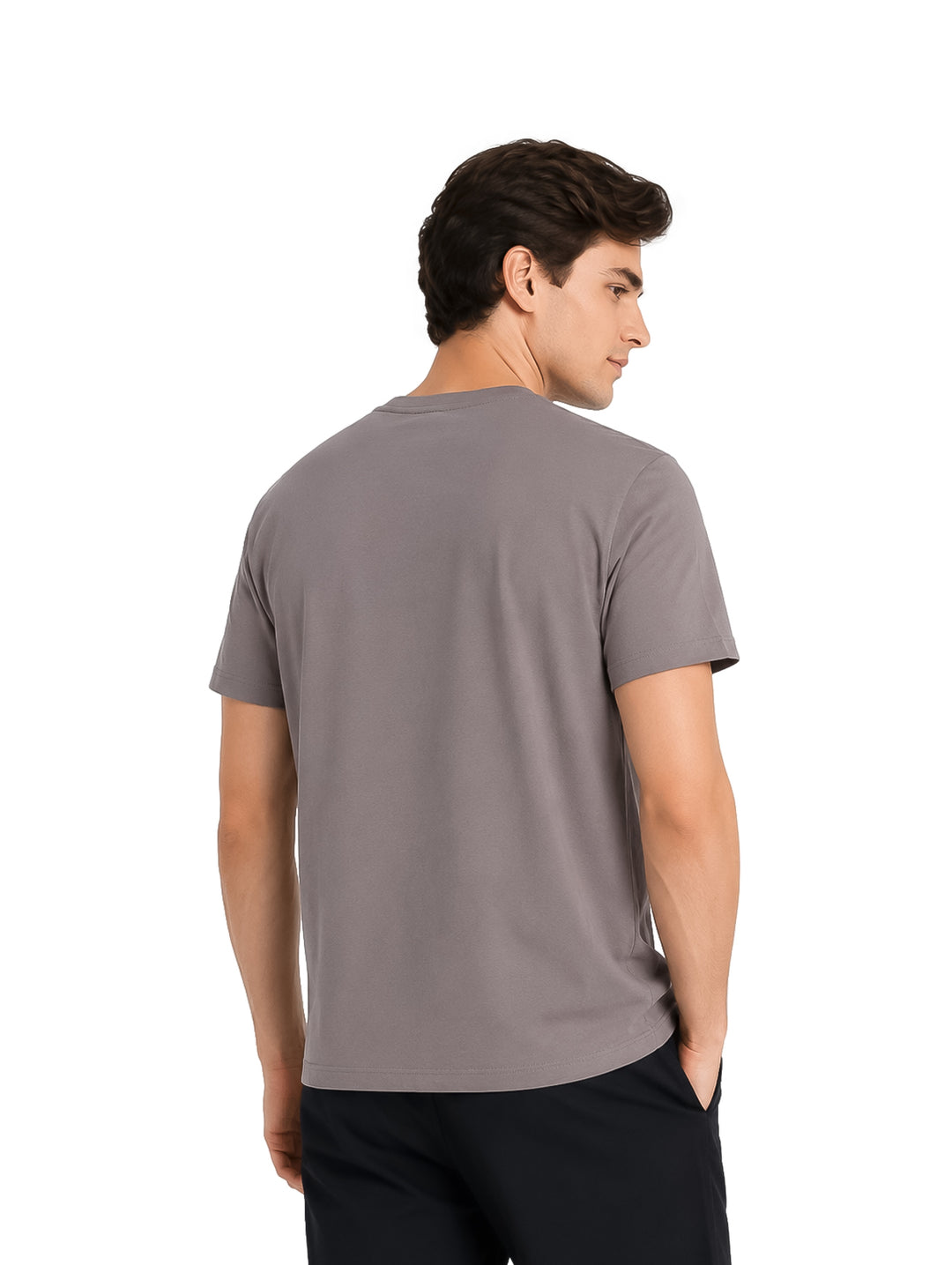 Hombre vistiendo playera K-Swiss color gris con detalle de texto negro en el pecho y pantalones negros.