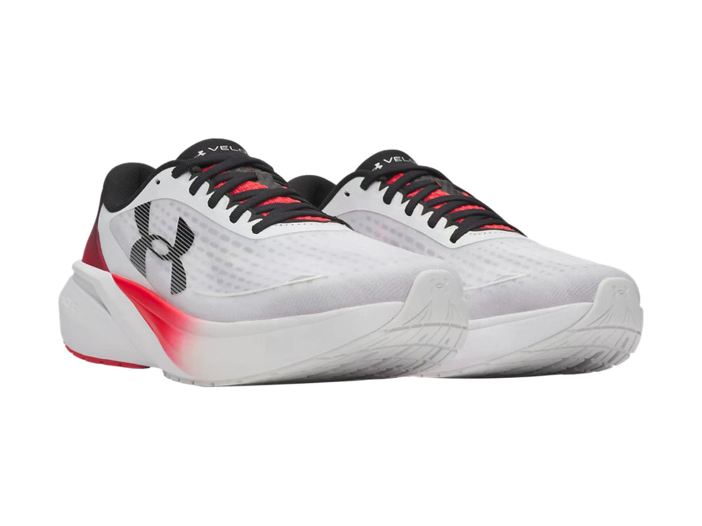 Tenis deportivos Under Armour blancos con detalles en degradado rojo y negro.
