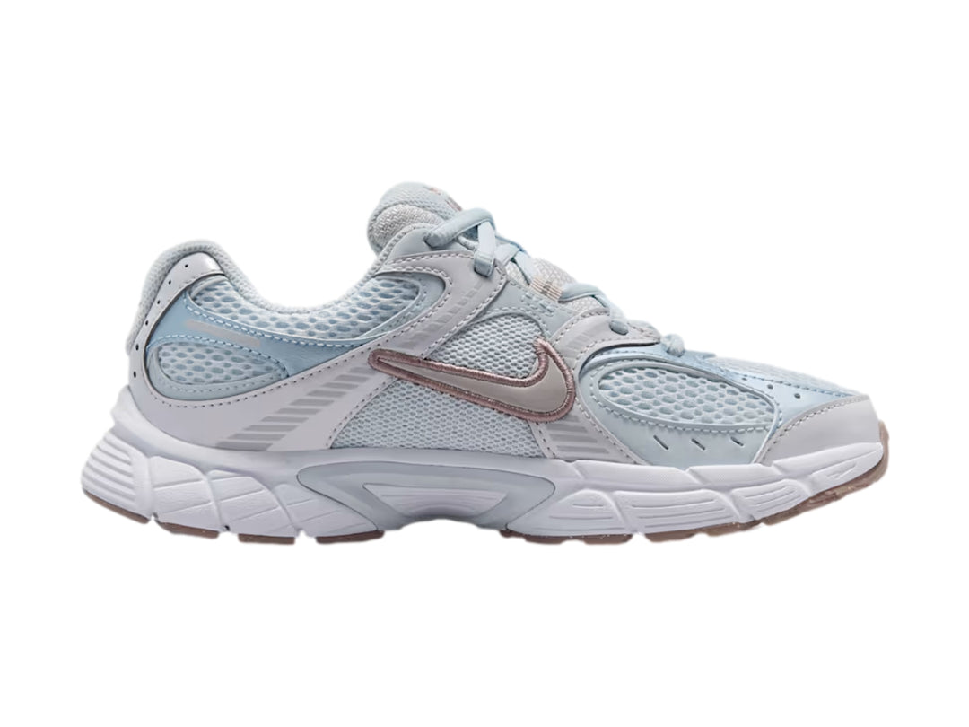 Tenis Nike deportivos color azul claro y blanco con suela blanca y detalles plateados.