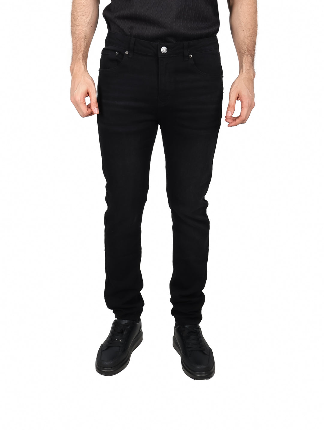 Hombre vistiendo pantalones jeans color negro de corte ajustado y zapatos negros.