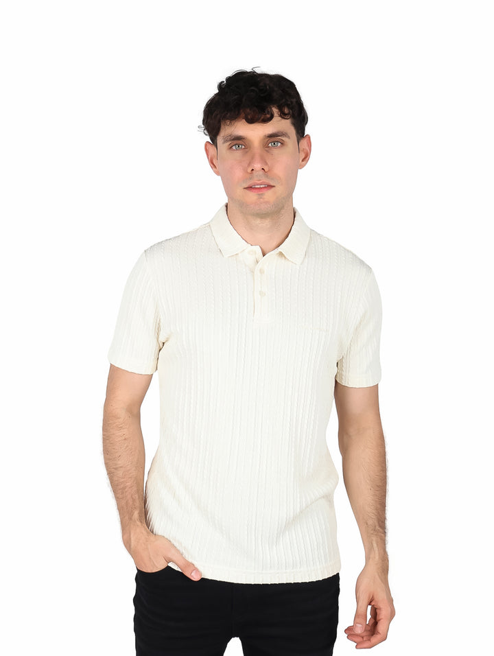 Hombre vistiendo playera polo color crema con textura acanalada.