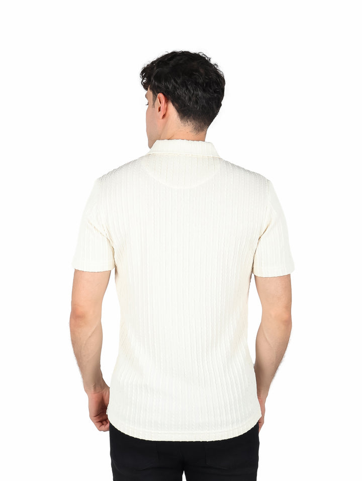 Hombre vistiendo playera polo color crema con textura acanalada.
